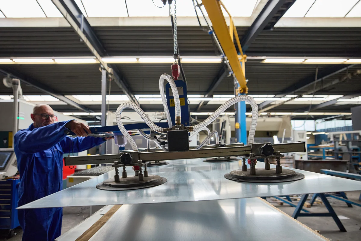 Een nieuwe plaat gaat met de vacuumkraan naar het snijbed